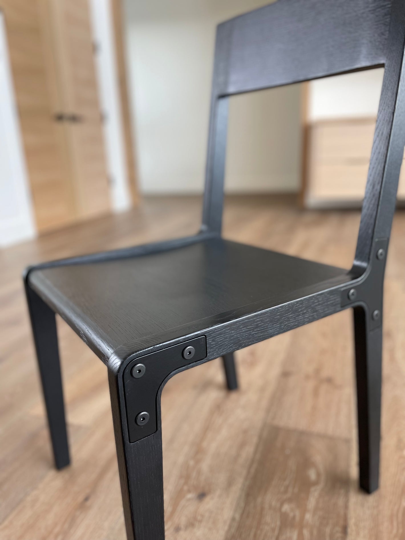 Modern dining chair with minimalistic design. Made from solid white oak and metal with a black hardware oil finish