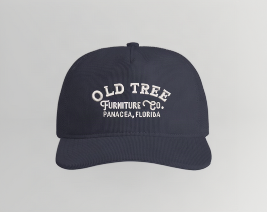 A dark navy blue baseball cap with white embroidered text reading 'OLD TREE FURNITURE Co. PANACEA, FLORIDA' on the front, shown against a plain white background.